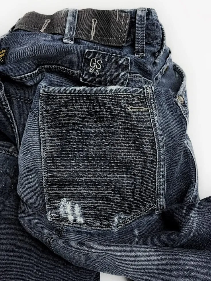 Jeans with a small woven patch and a heavily reinforced, sashiko-stitched back pocket panel.