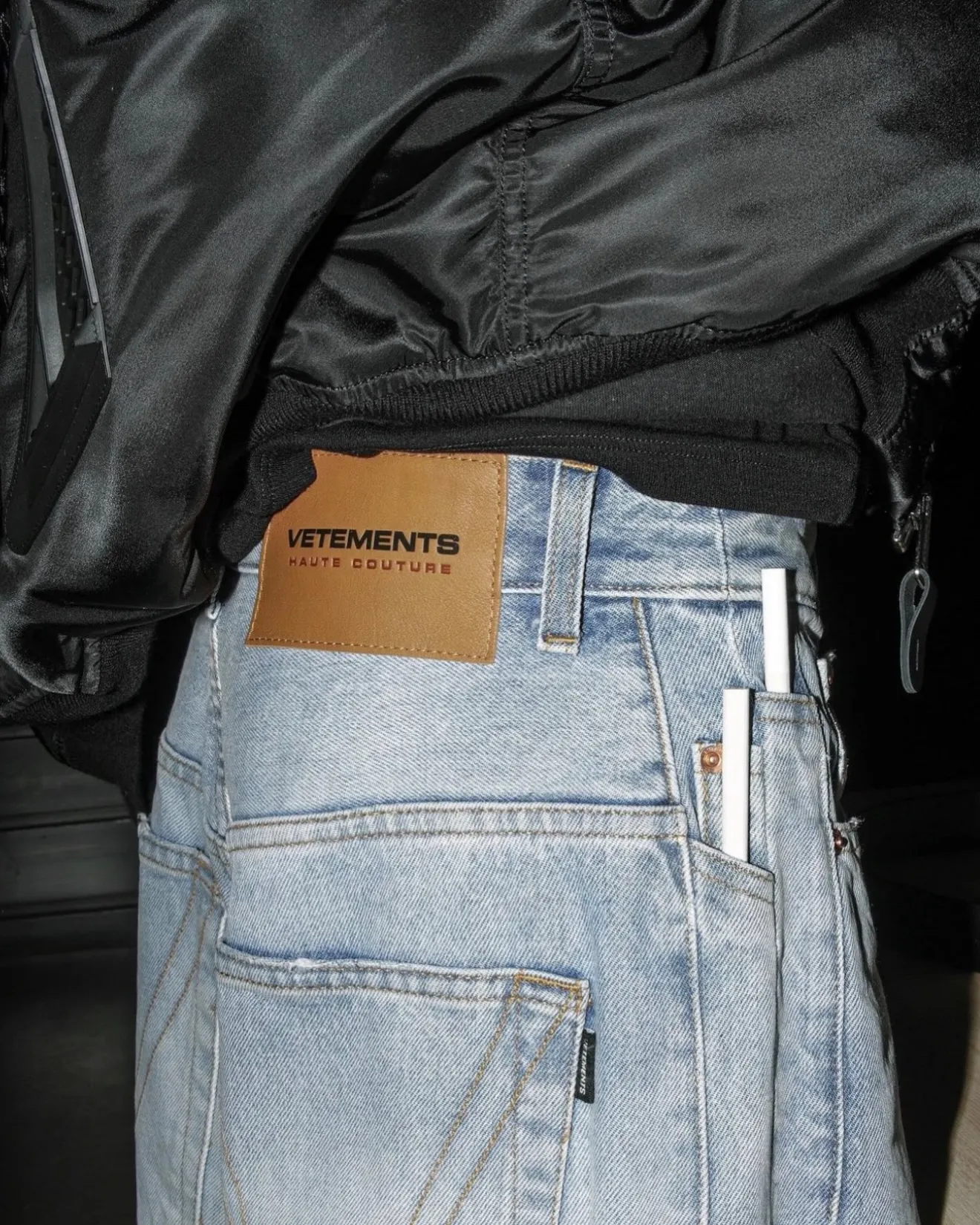 Close-up of Vetements jeans, showing an oversized tan leather patch stamped VETEMENTS HAUTE COUTURE.
