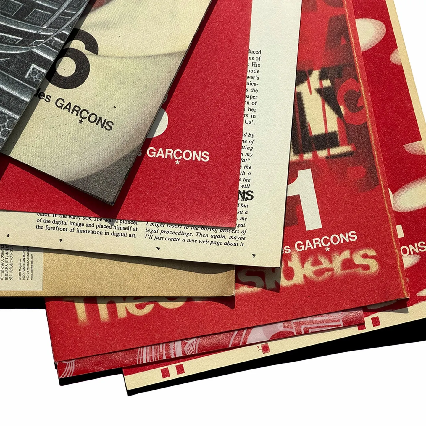 Flatlay of seven Comme des Garcons WERK direct mail issues from 2016, numbered 1, 6, 8, 9, 20, 21 and 22.